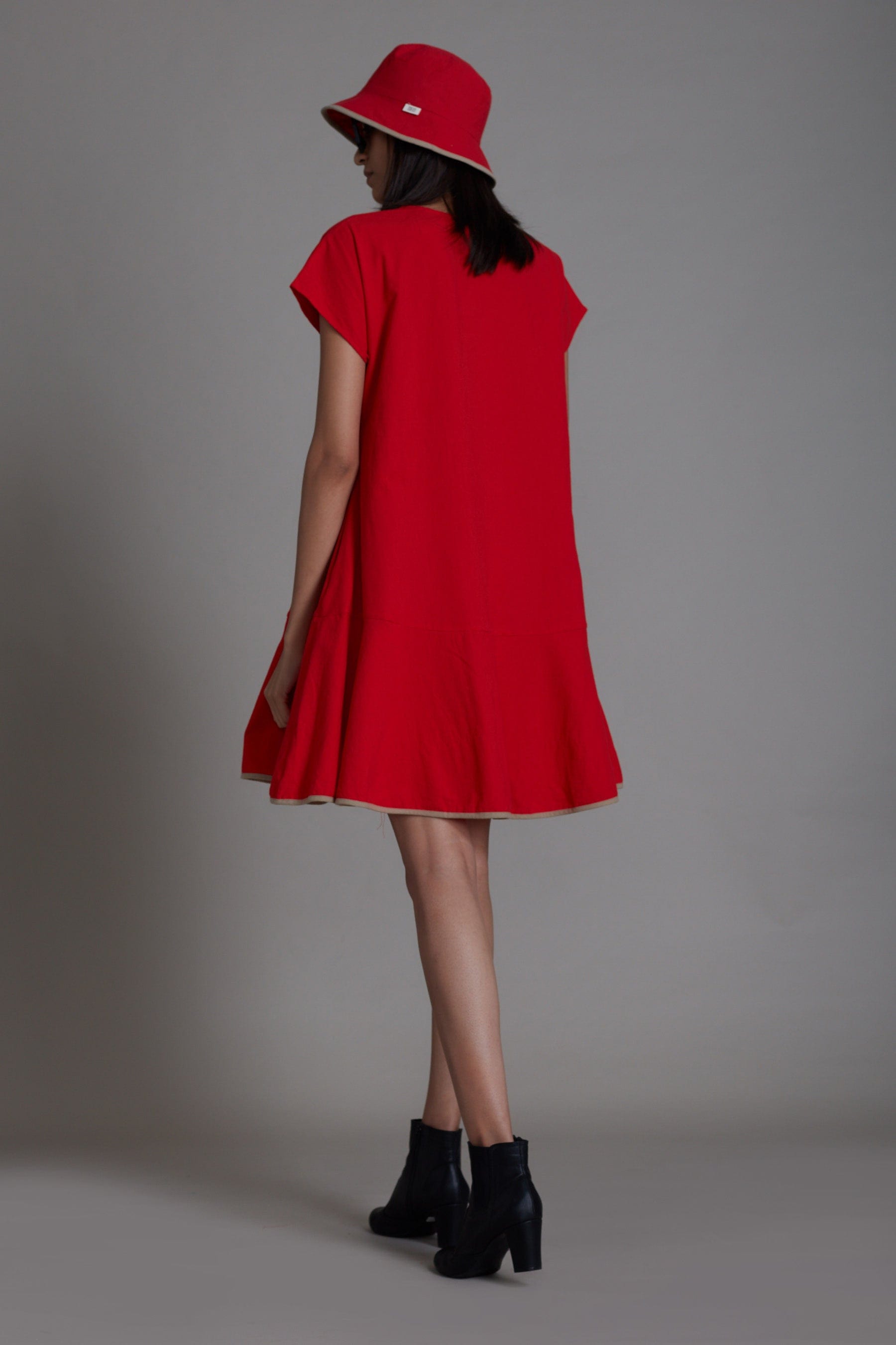 Handwoven cotton A-line dress in red with flared hem, contrast piping and side pockets, by MATI India