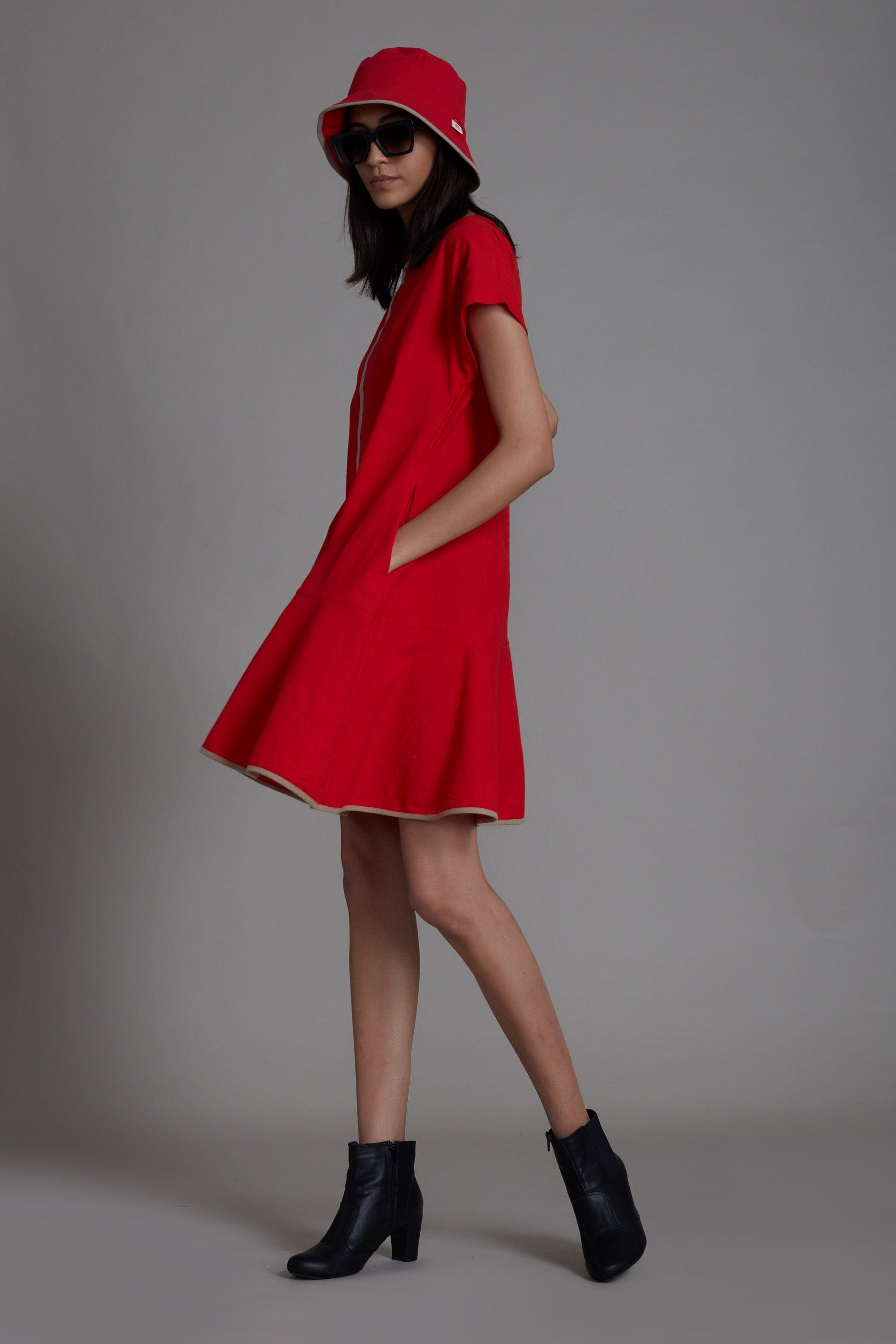 Handwoven cotton A-line dress in red with flared hem, contrast piping and side pockets, by MATI India