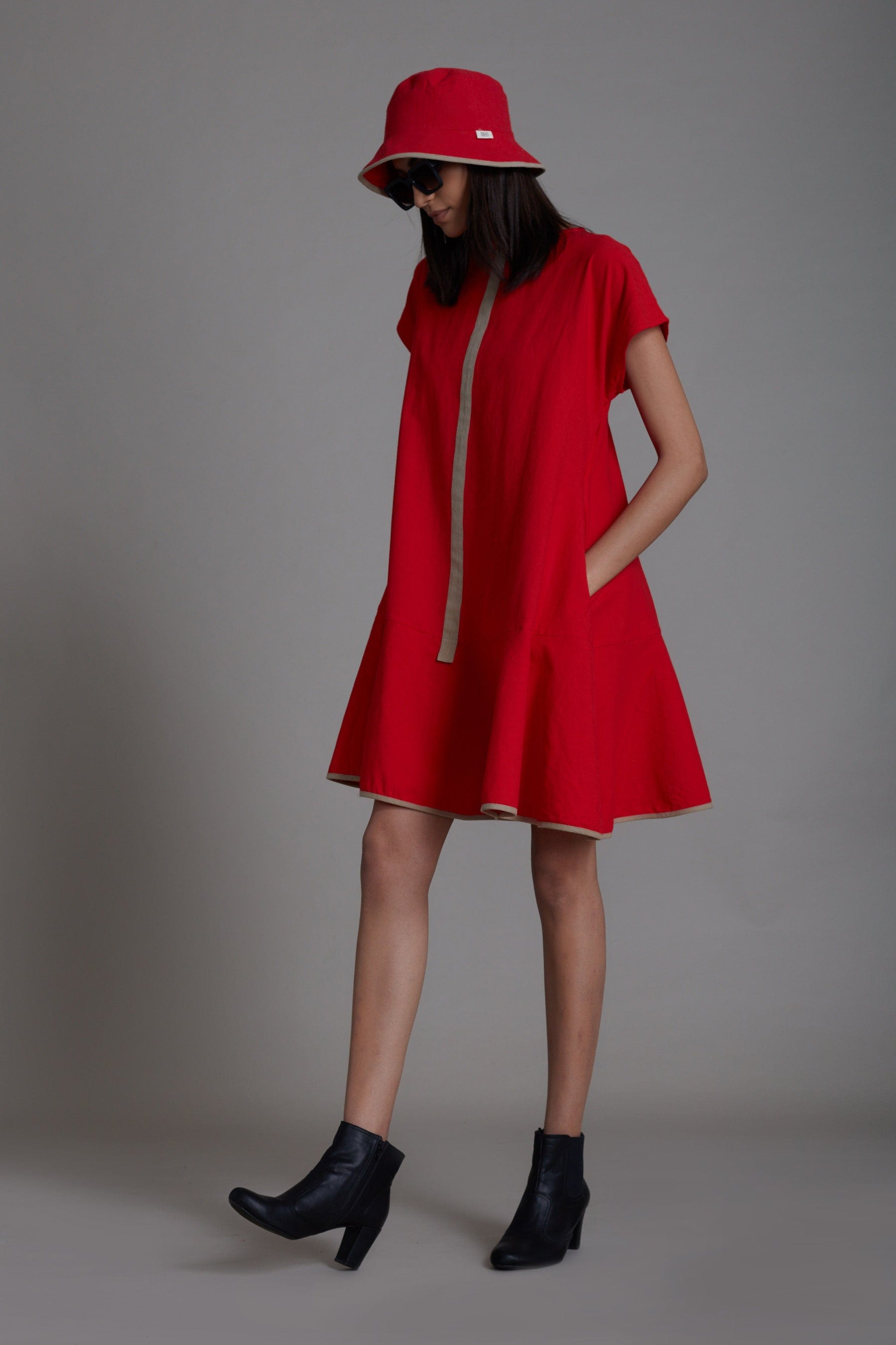 Handwoven cotton A-line dress in red with flared hem, contrast piping and side pockets, by MATI India
