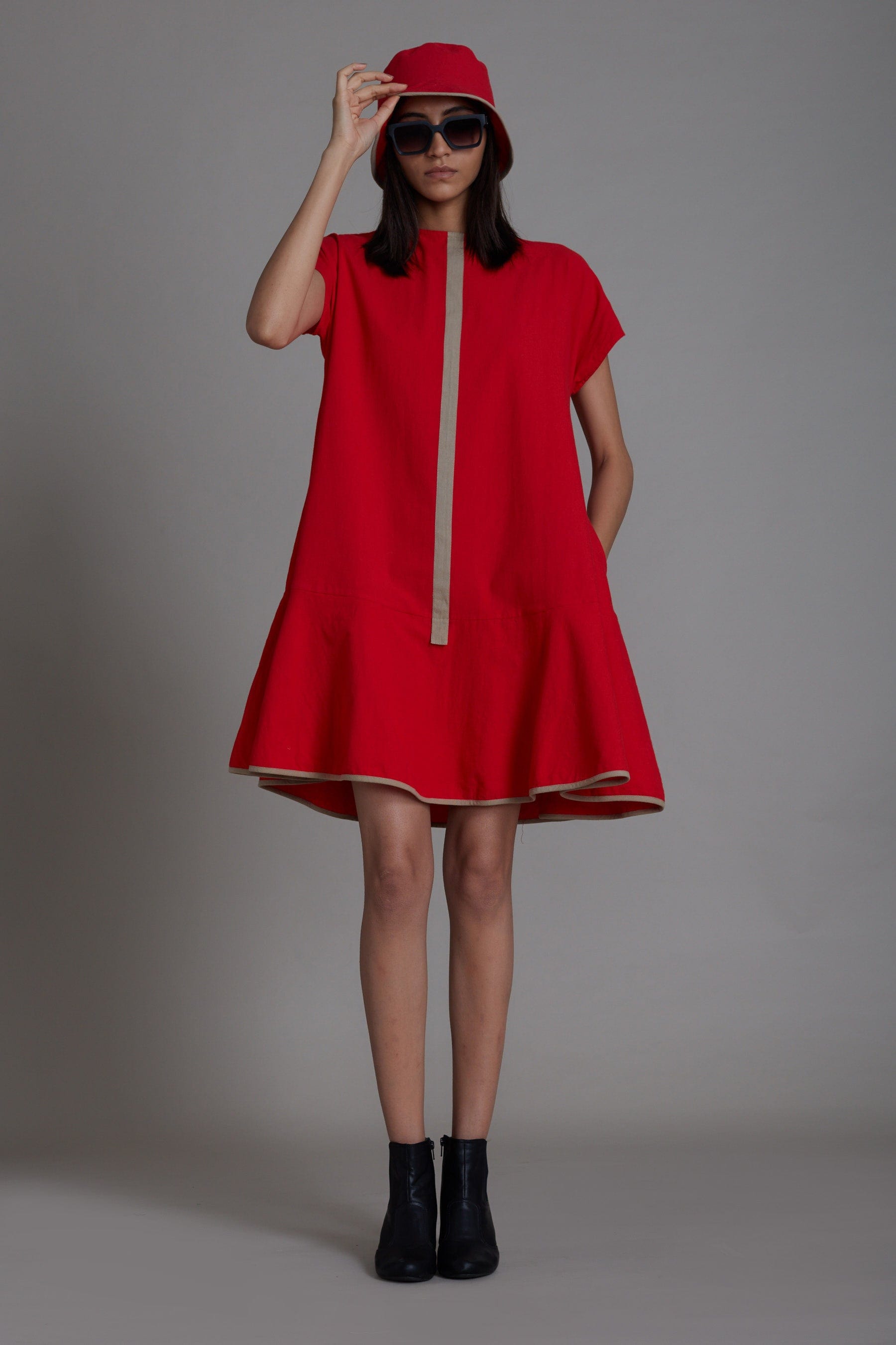 Handwoven cotton A-line dress in red with flared hem, contrast piping and side pockets, by MATI India